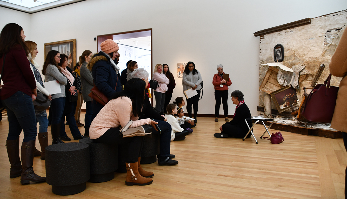 A Museum docent speaks in front of Titus Kaphar's "Umbrella Wall #2 (The Vesper Project)"